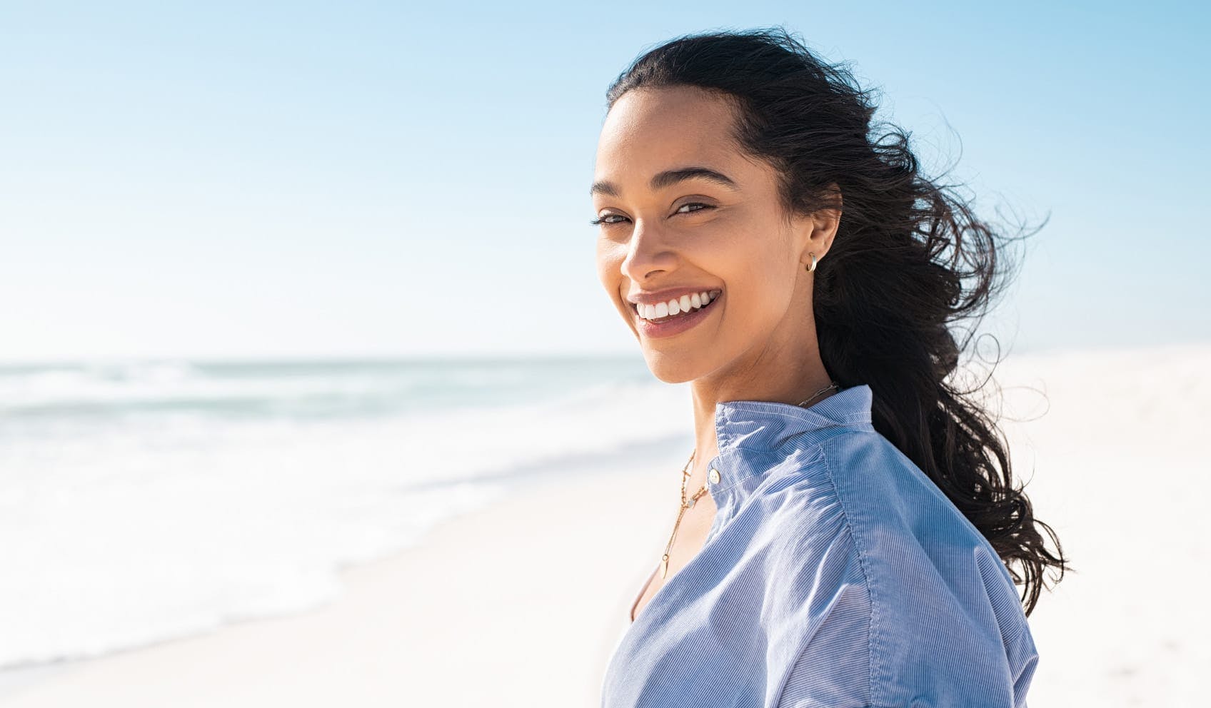 Woman smiling and standing on the beach