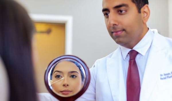 Dr. Ashkay Sanan holding mirror for patient