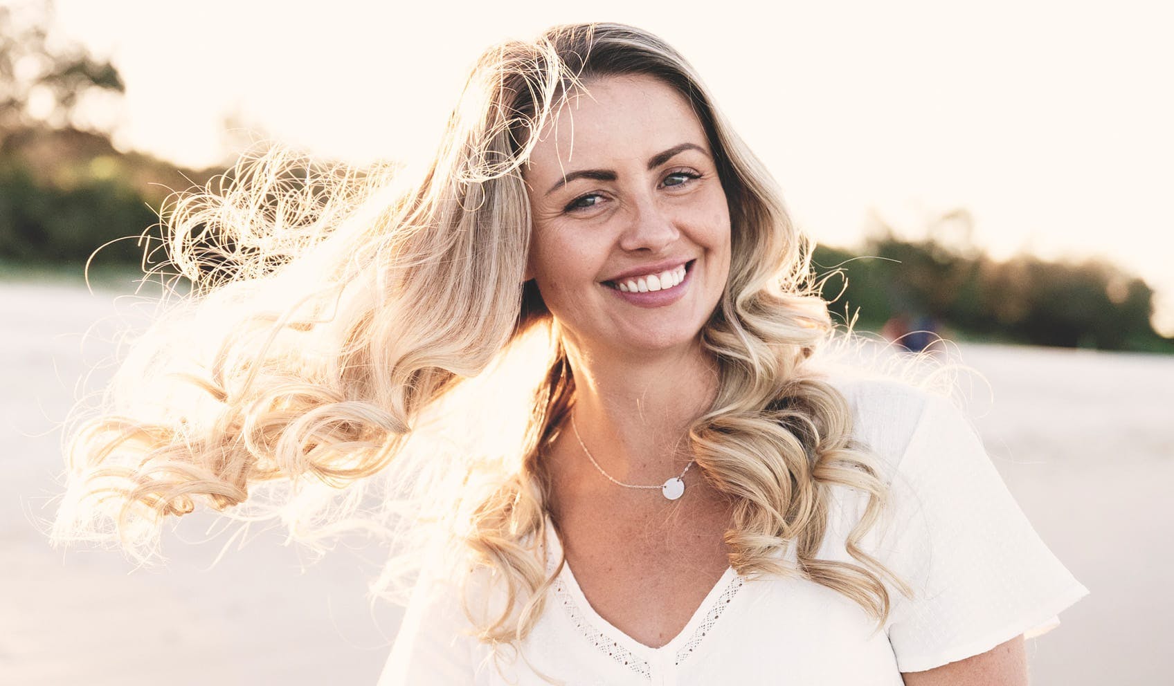 woman smiling with hair waving from the wind