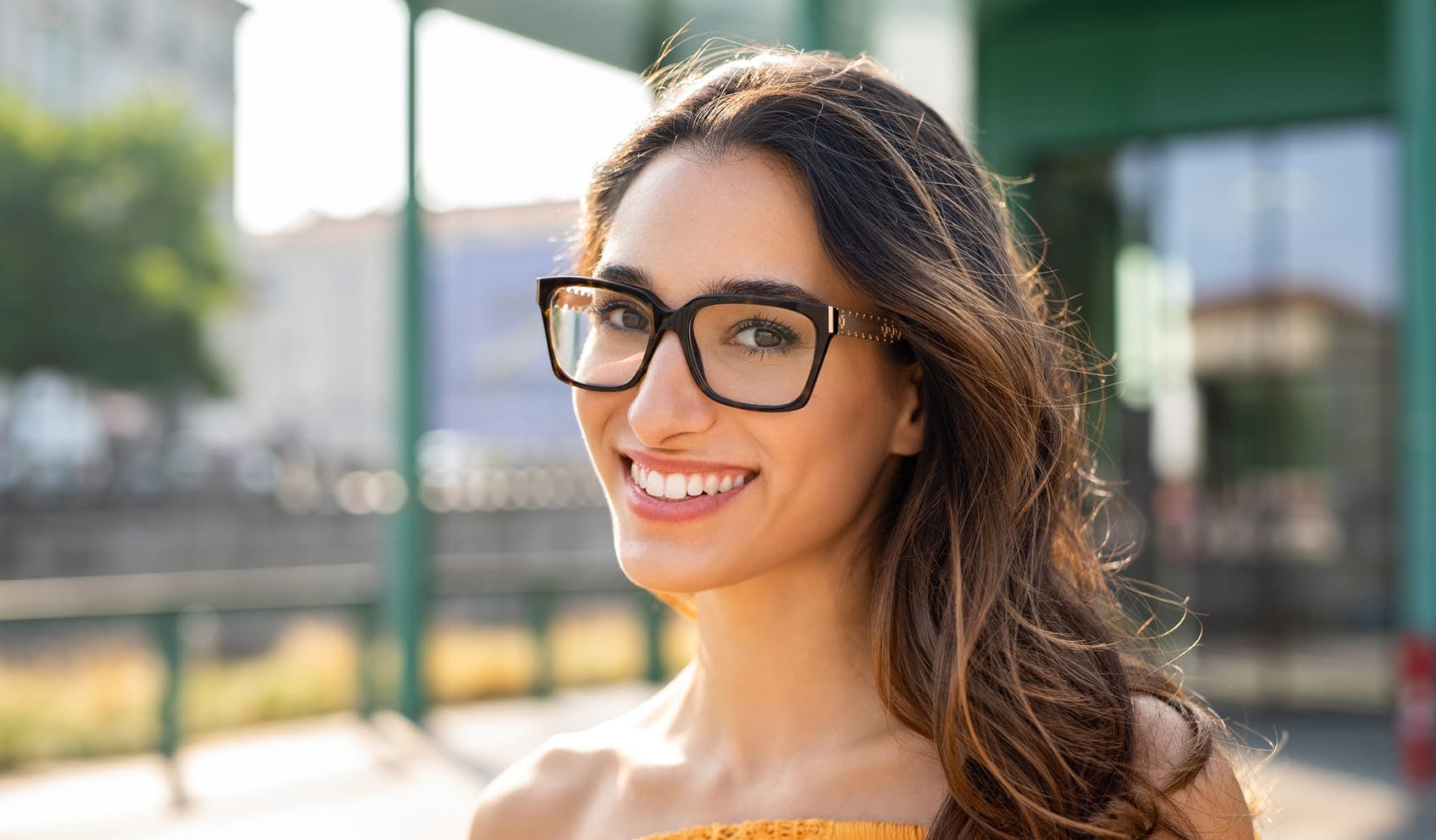Woman smiling wearing glasses outside