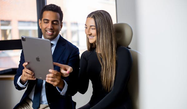 Dr. Akshay Sanan showing smiling patient something on tablet