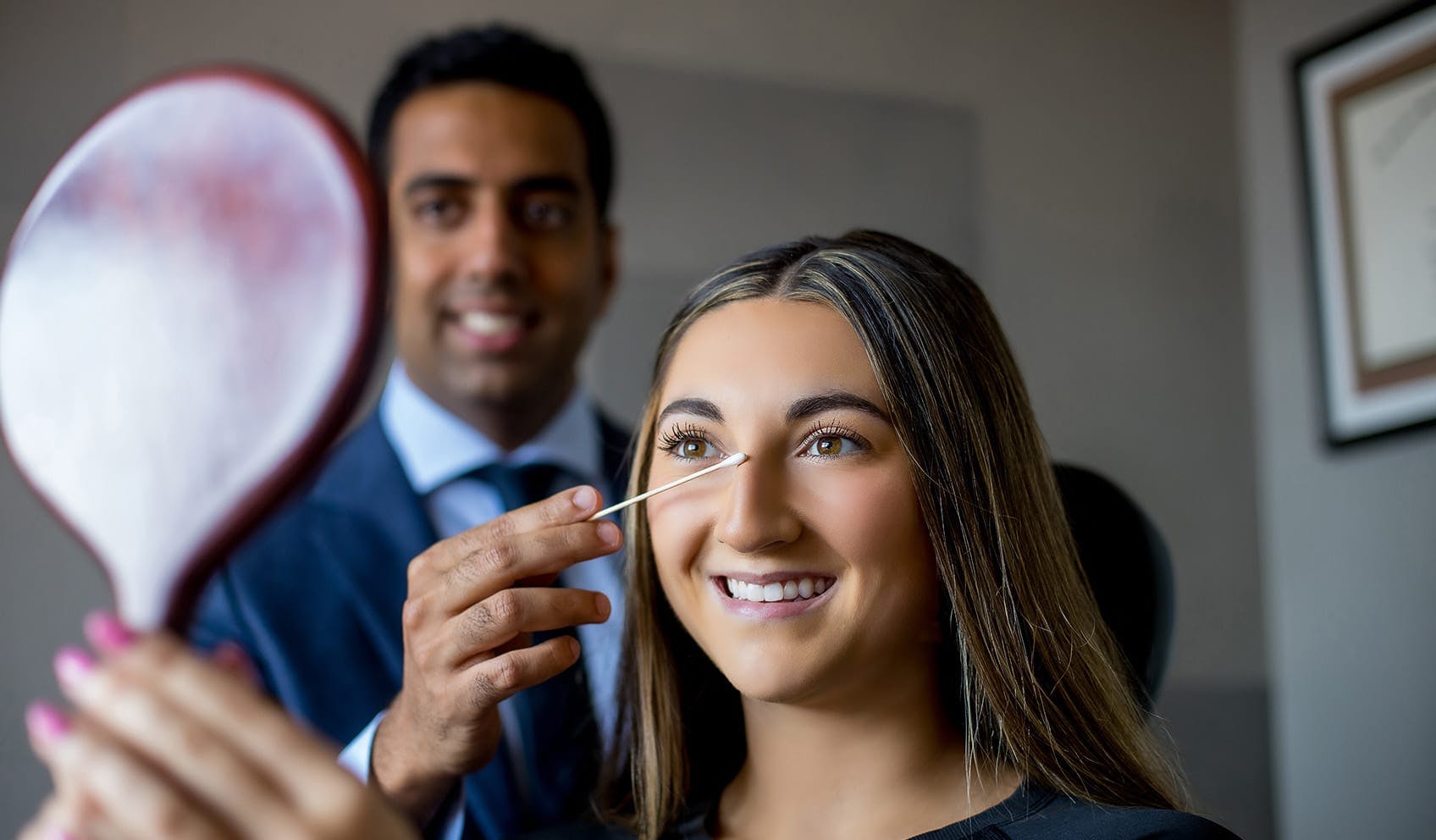 Dr. Akshay holding mirror in front of patient