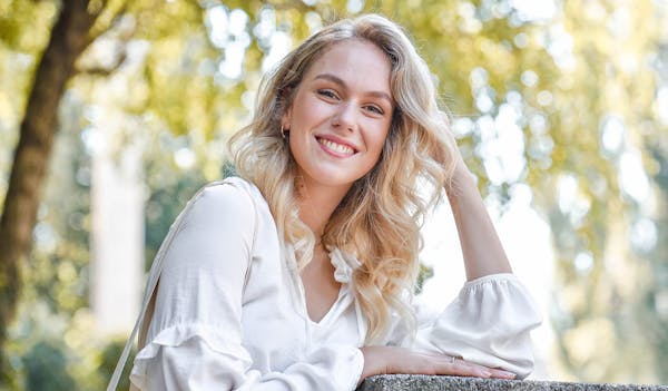 Woman smiling in the outdoors resting head
