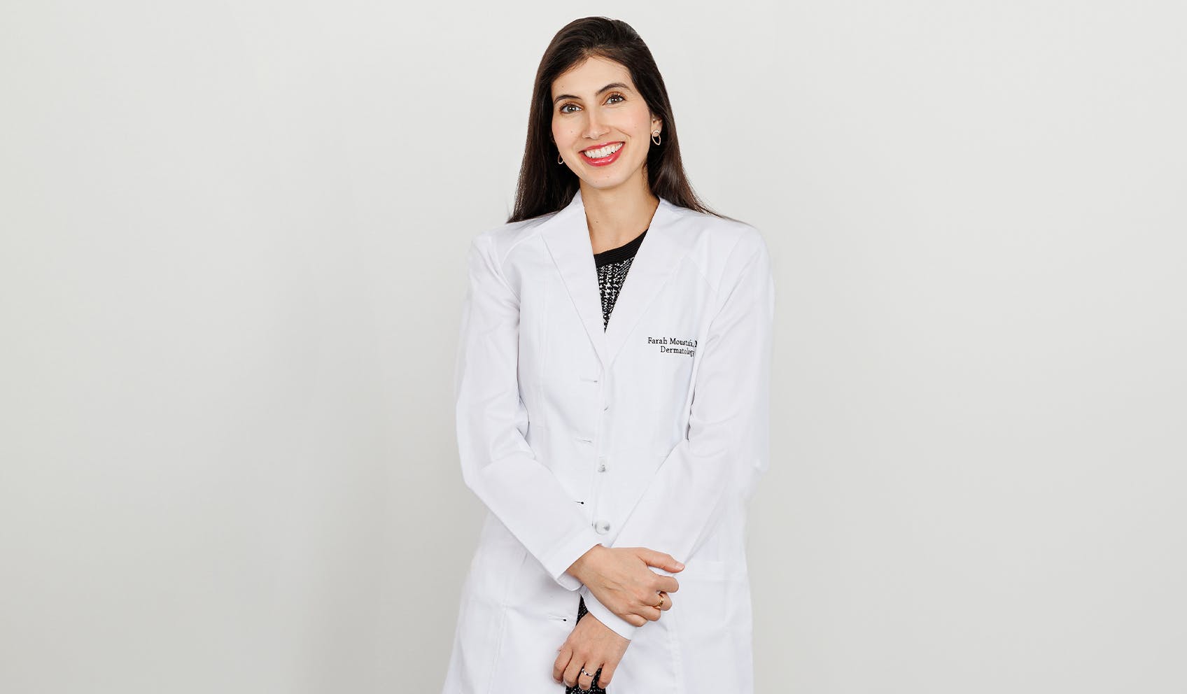 Dr. Farah Moustafa in doctor coat smiling