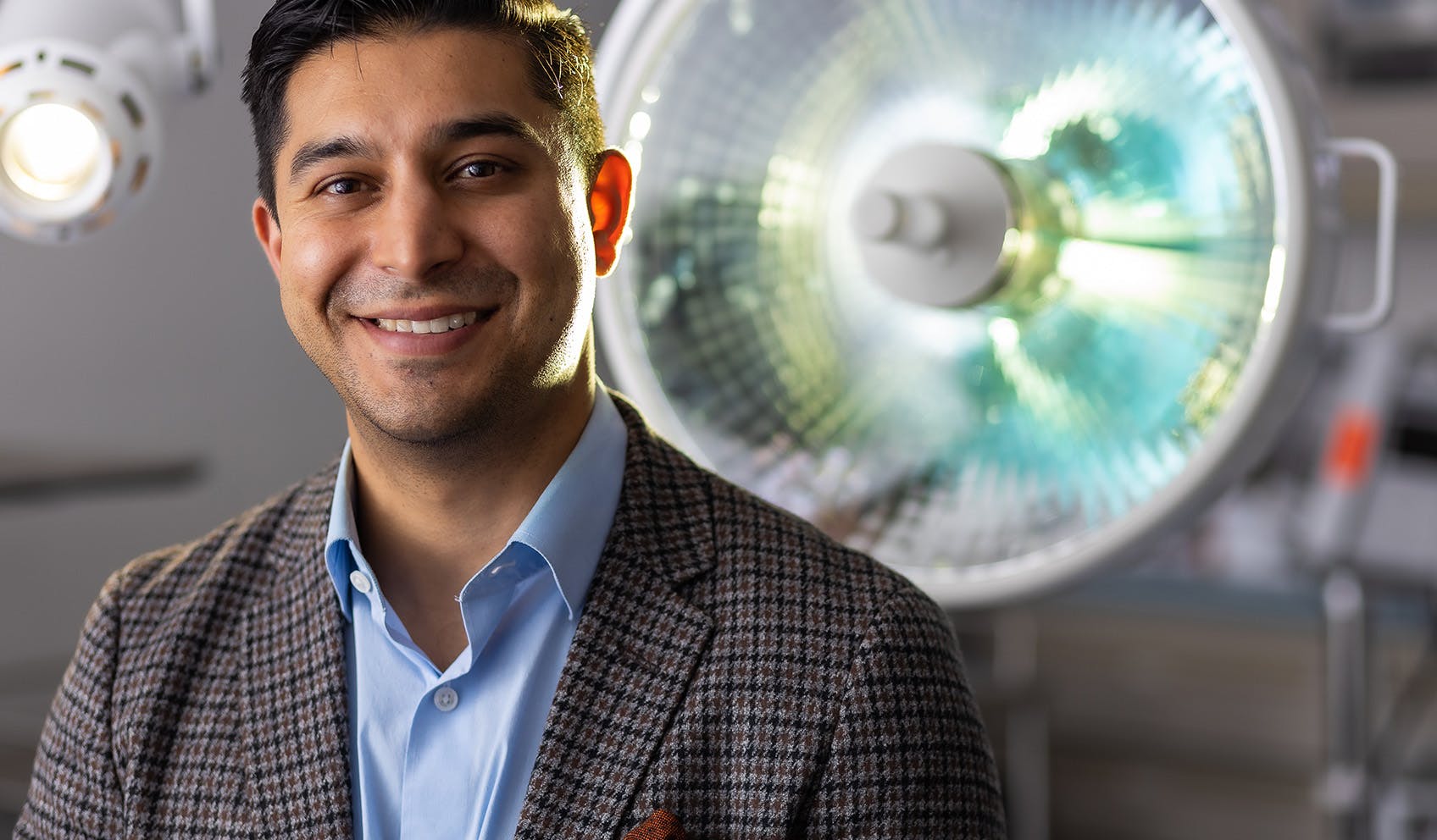 Dr. Vickram Tandon Smiling in front of surgery room light