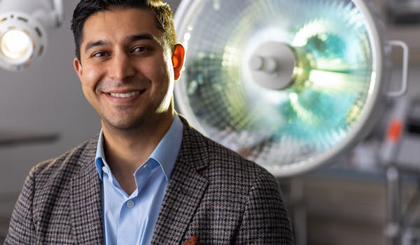 Dr. Vickram Tandon Smiling in front of surgery room light