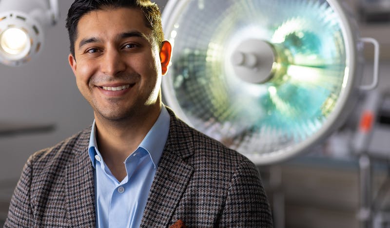 Dr. Vickram Tandon Smiling in front of surgery room light