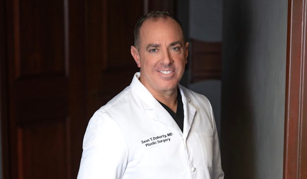 Dr. Sean Doherty smiling in white lab coat