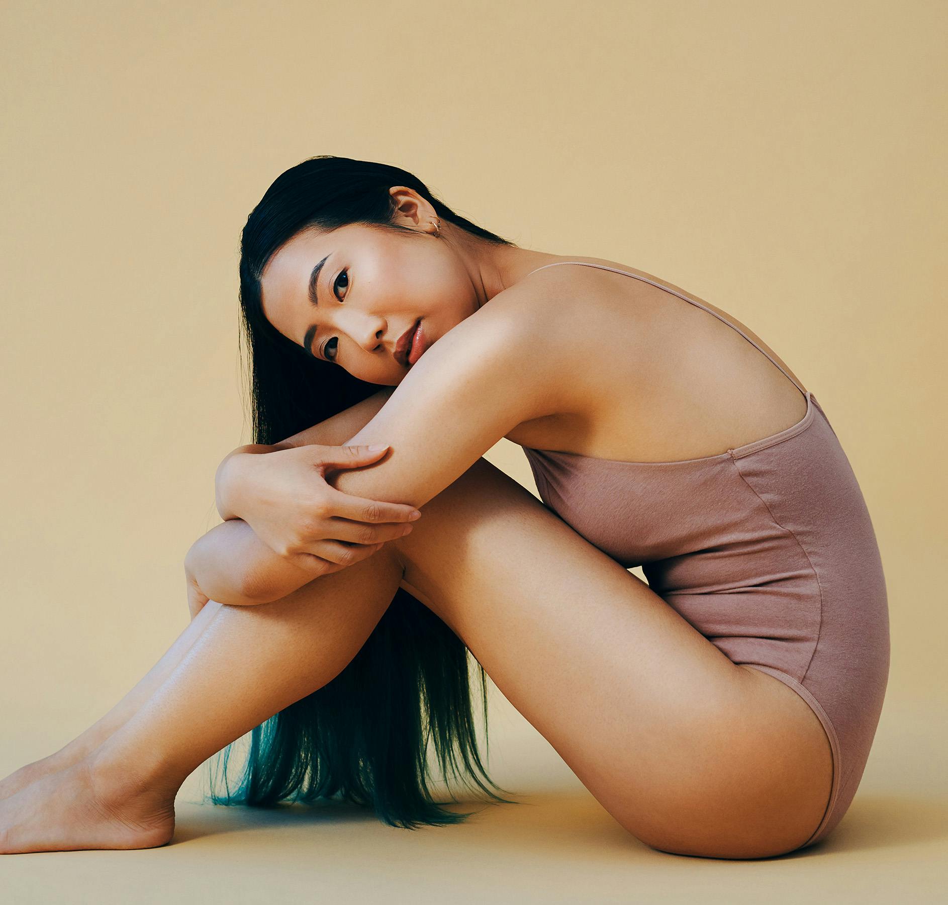 hugging legs soft yellow background