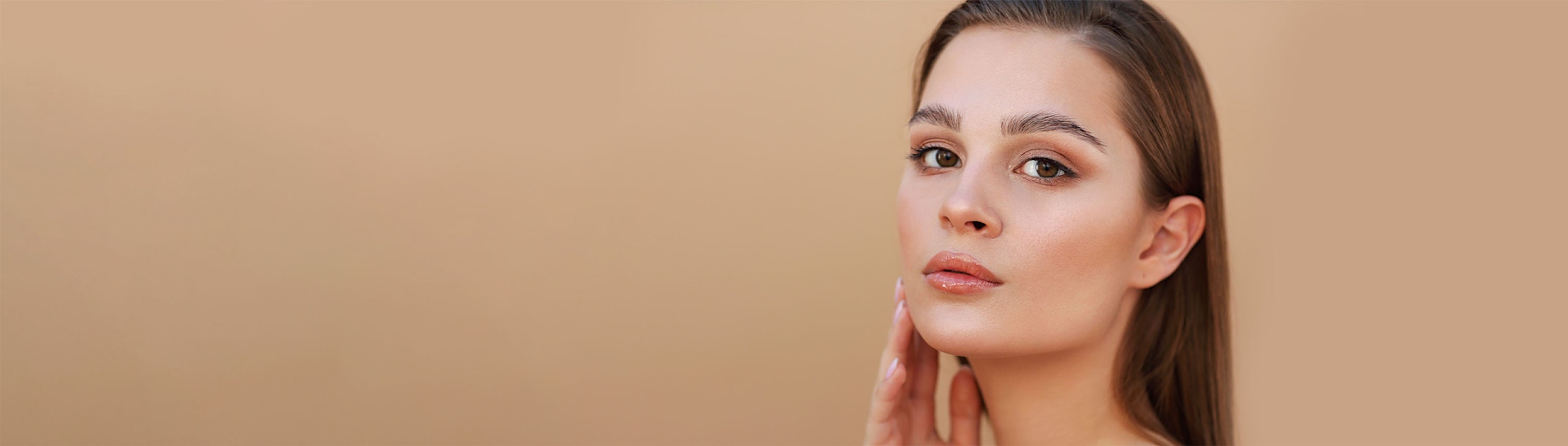 hand on cheeck slight glance light brown background