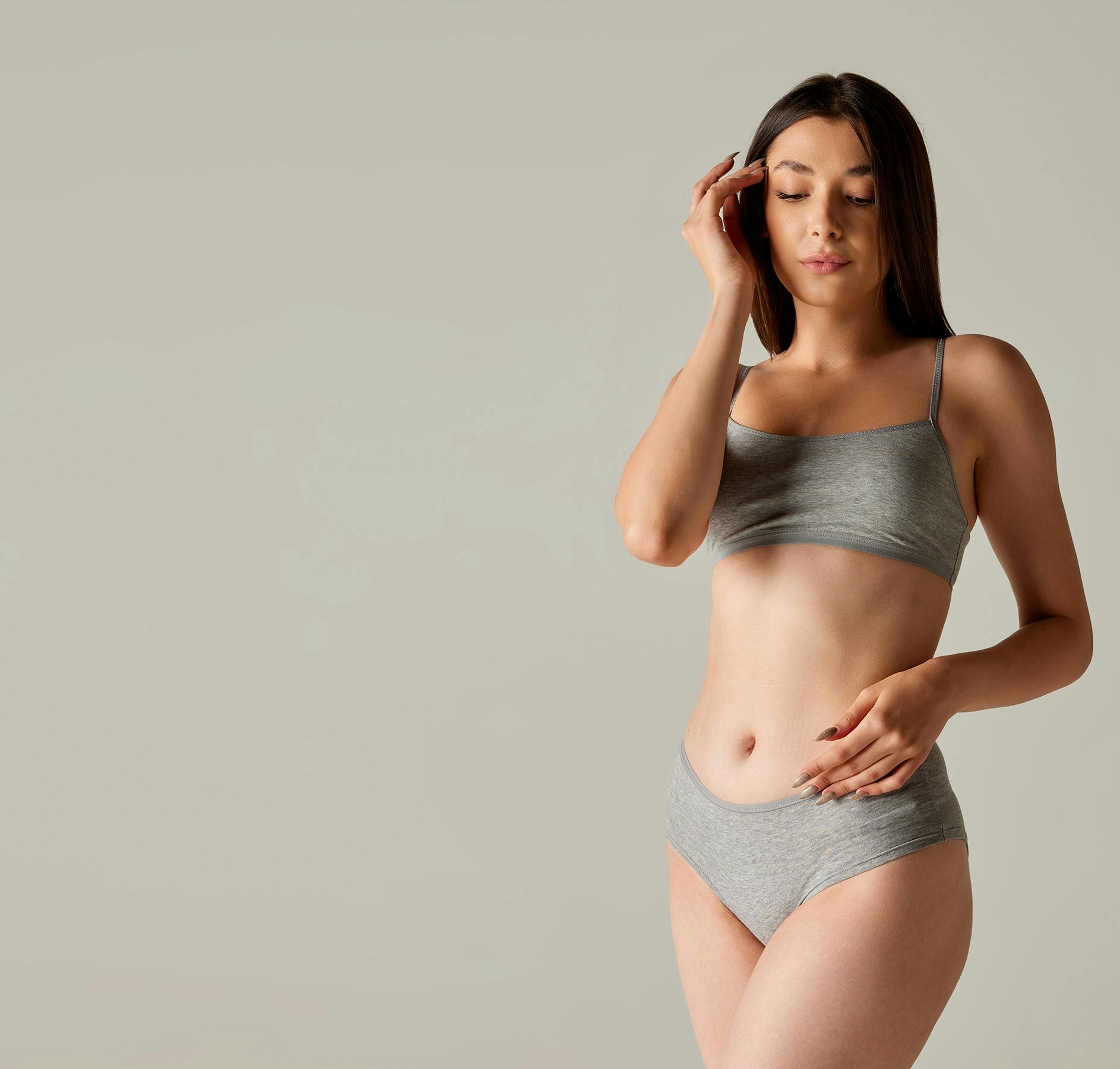 woman in a gray bra top and panties posing for a picture