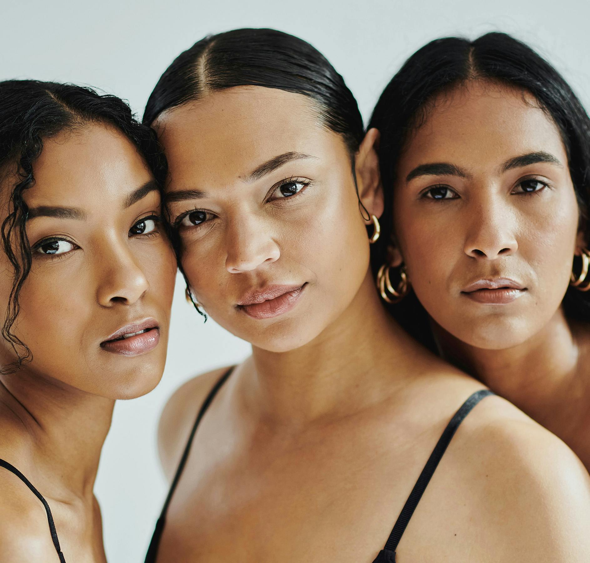 three women in black bra tops posing for a picture