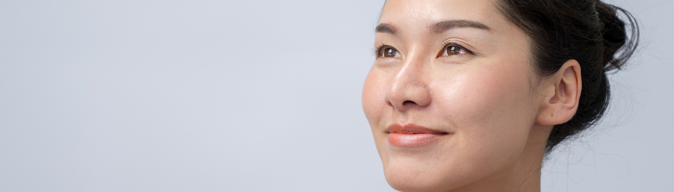 eyes closed hands cradling face light brown background