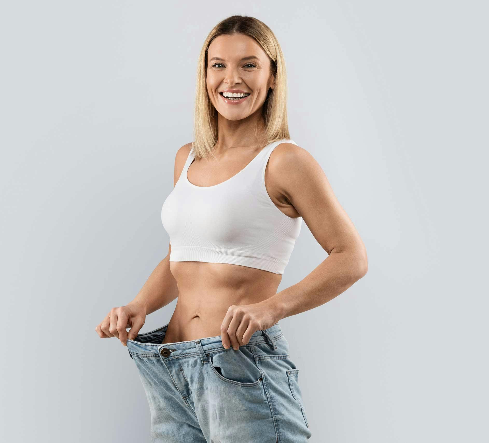 trim woman holdinng jeans away from waist