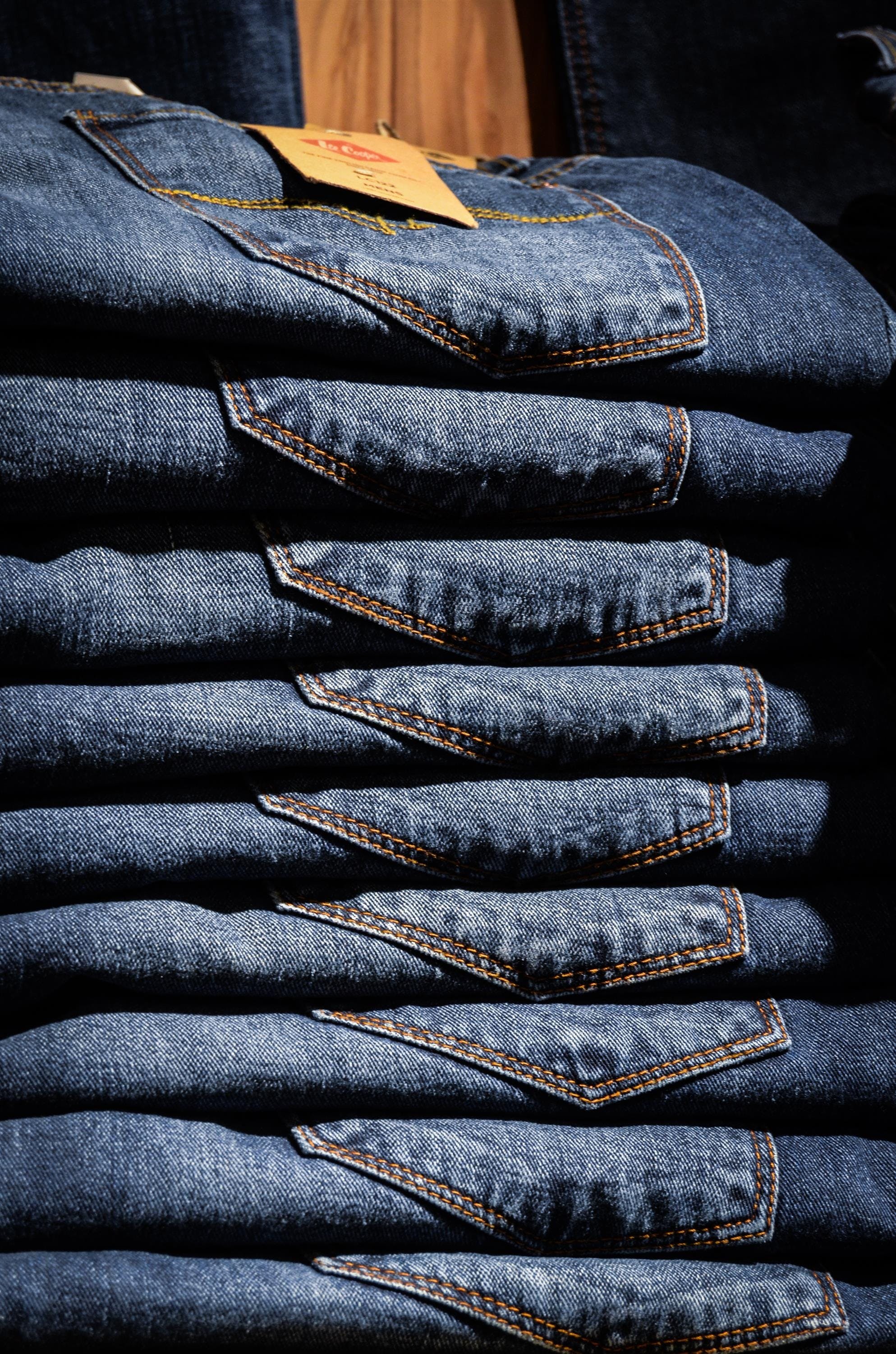Blue jeans stacked on top of eachother.