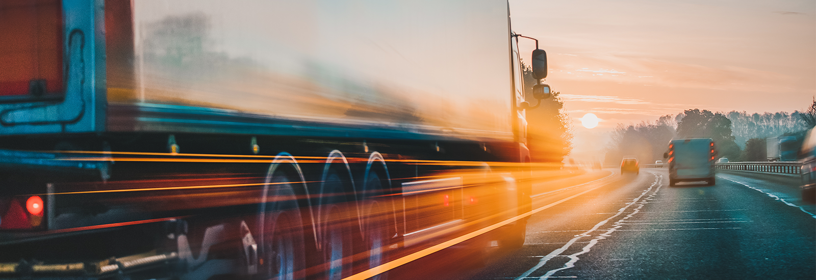 Trucks on a highway in sunset