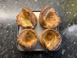 A baking tray with 4 beautifully risen Yorkshire puddings