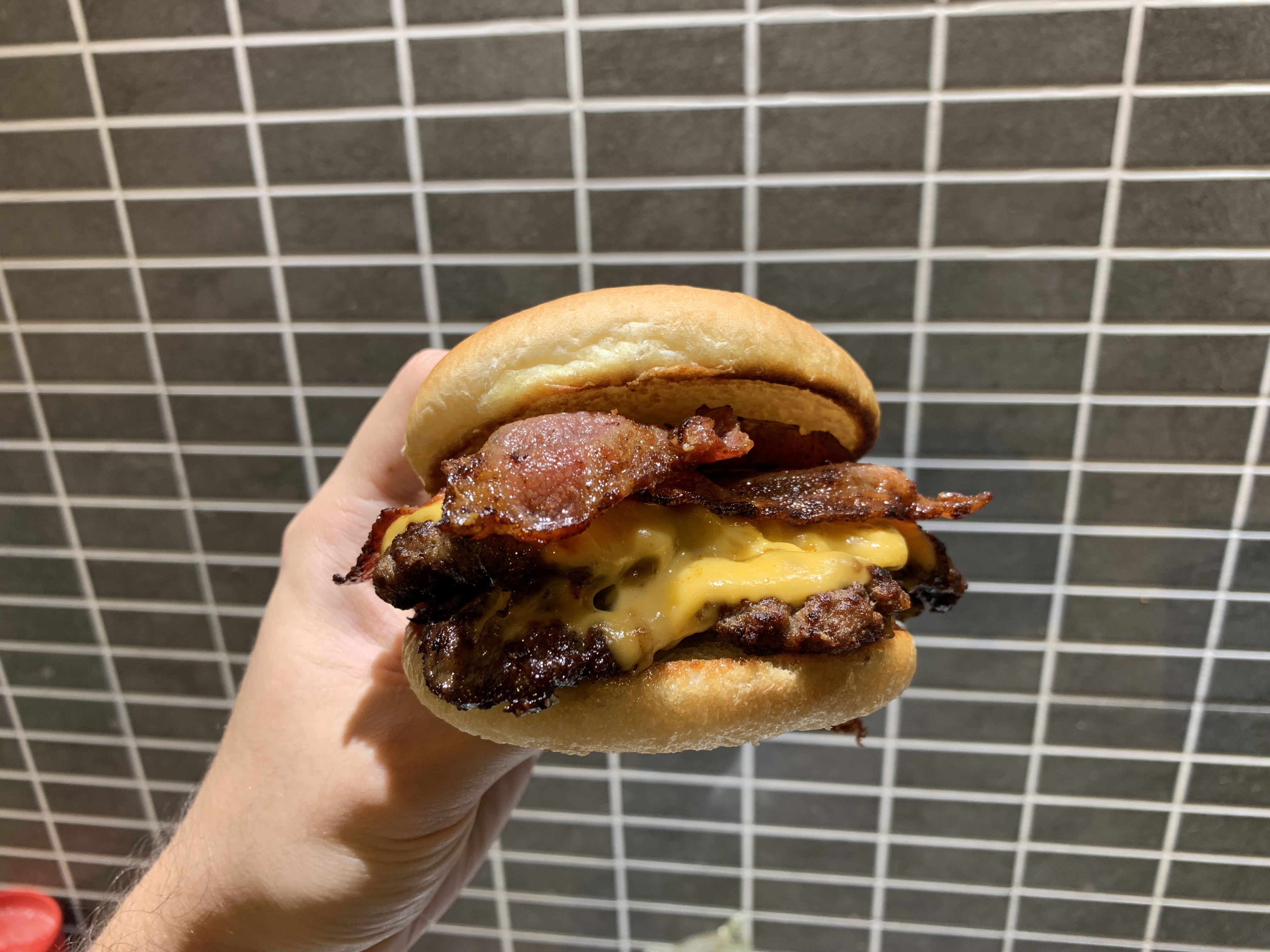 A double smashed burger with cheese and bacon