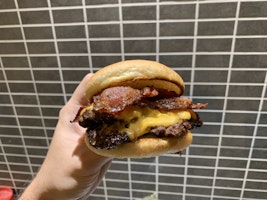 A double smashed burger with cheese and bacon