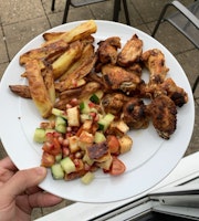 A plate of chicken wings, chips and halloumi salad