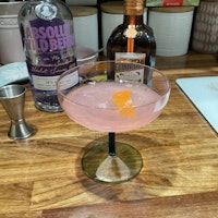 Cocktail glass of cosmopolitan with garnish of orange zest