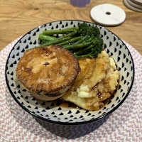 A steak & ale pie with mash, gravy and broccoli