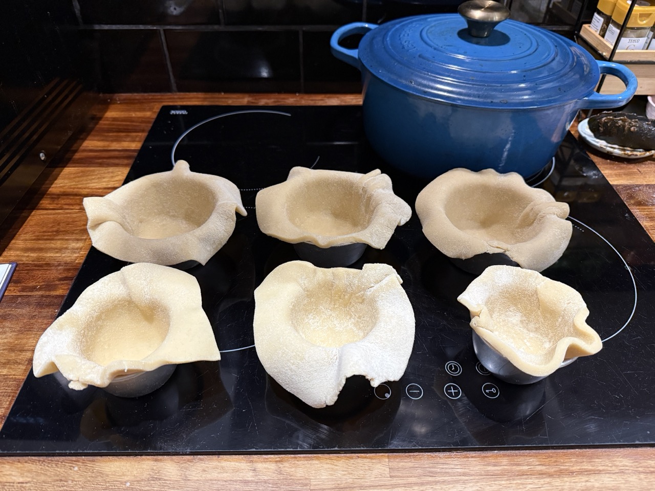 Pie moulds fitted with the hot water pastry waiting for filling to be added