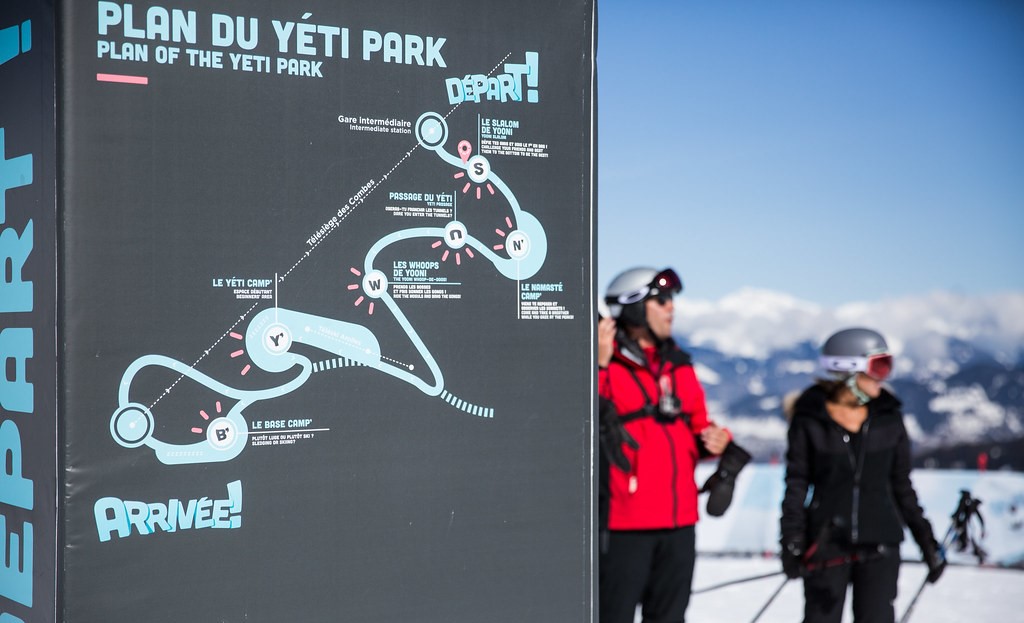 map of the Yéti Park ski area on a sign, on the right two skiers wearing helmets