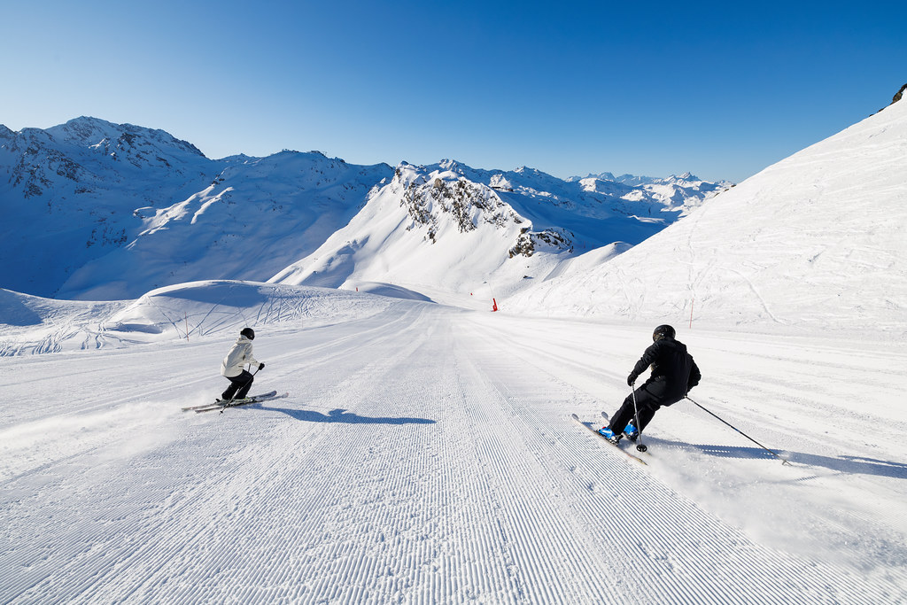 2 skiers skiing on a freshly groomed slope in Méribel