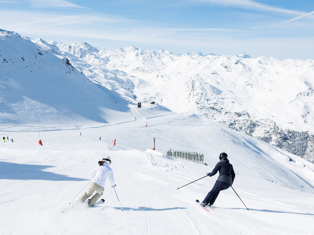 Deux skieuses au sommet de la Saulire, profitant de la liaison entre Courchevel et Méribel dans les 3 Vallées.