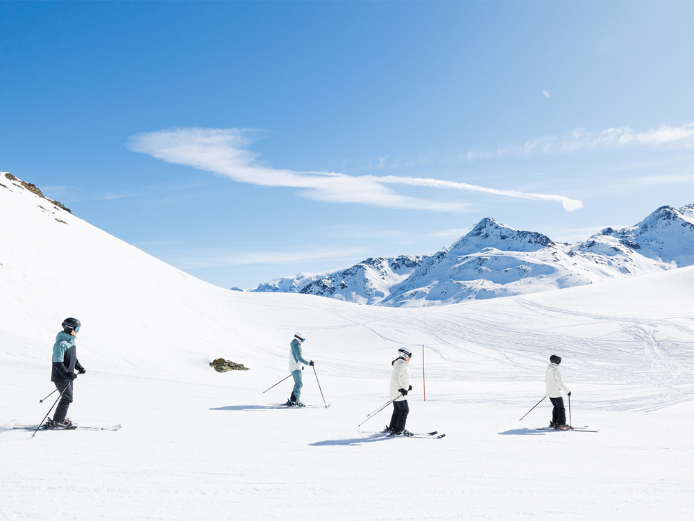 Groupe de 4 personnes skiant sur une piste rouge à Méribel