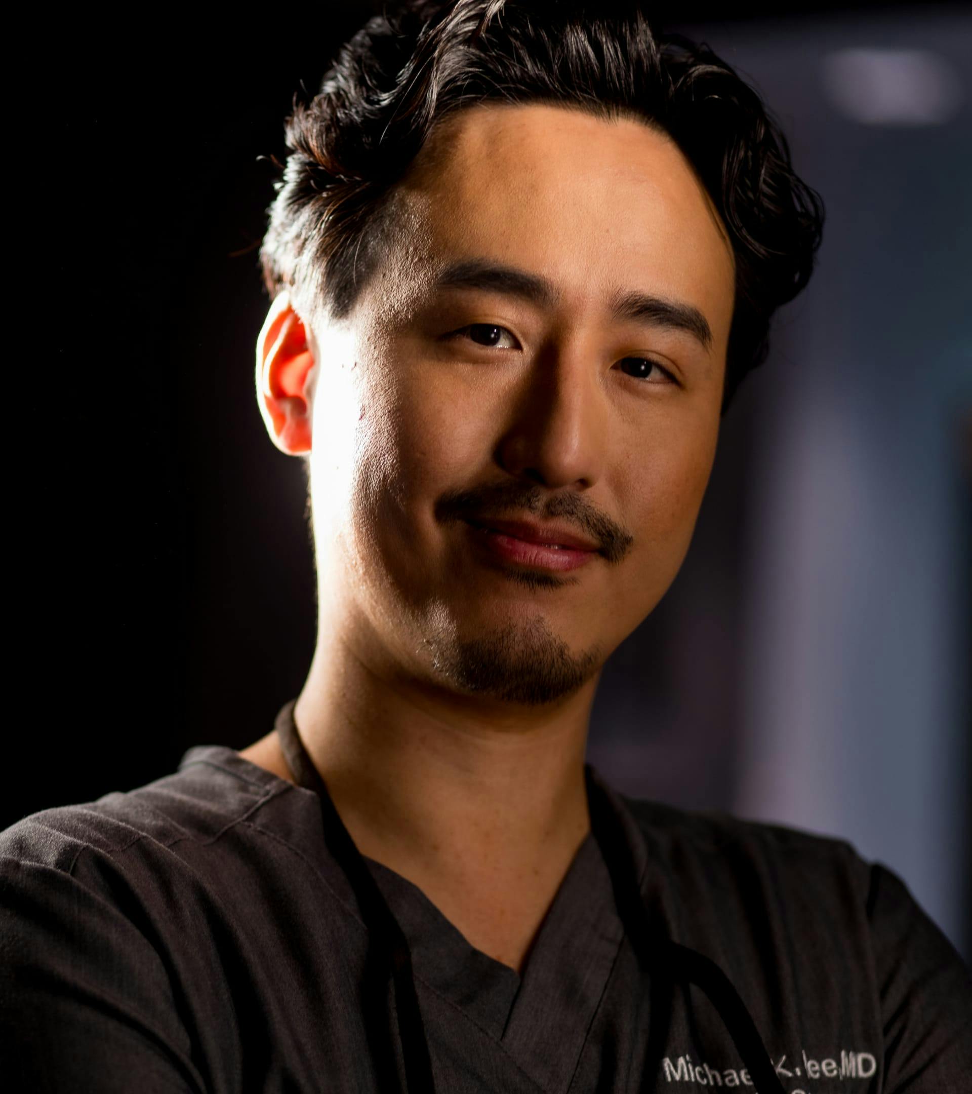Dr. Michael K. Lee in black scrubs