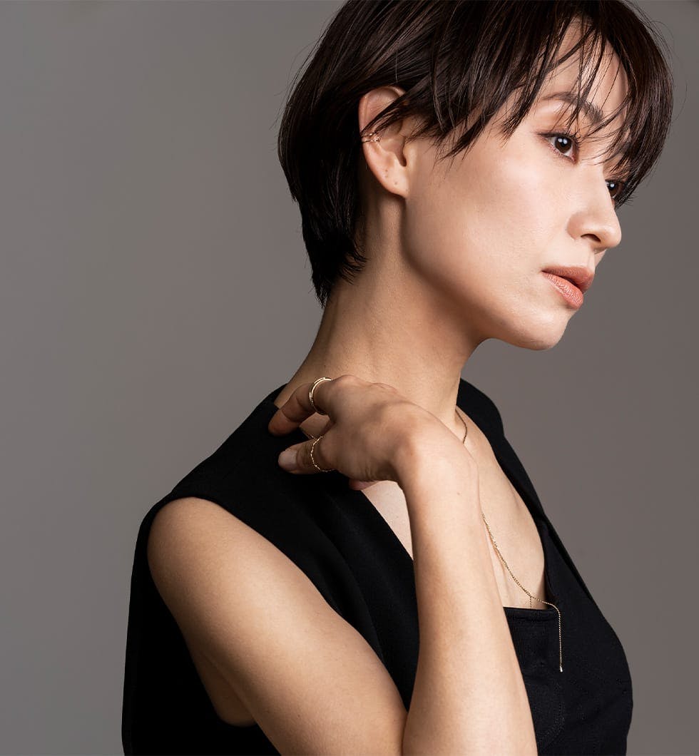 woman with a black top and a necklace on