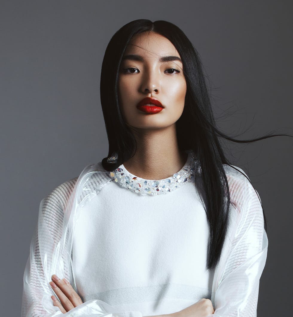 woman with long black hair and red lipstick posing for a picture