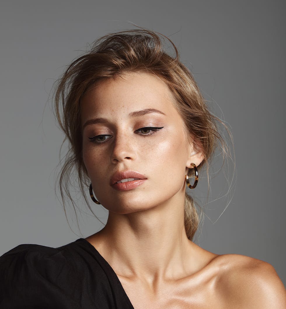 woman in a black dress with a black top and earrings