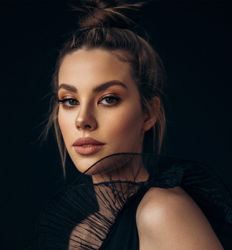 woman with black ornamental dress posing for picture