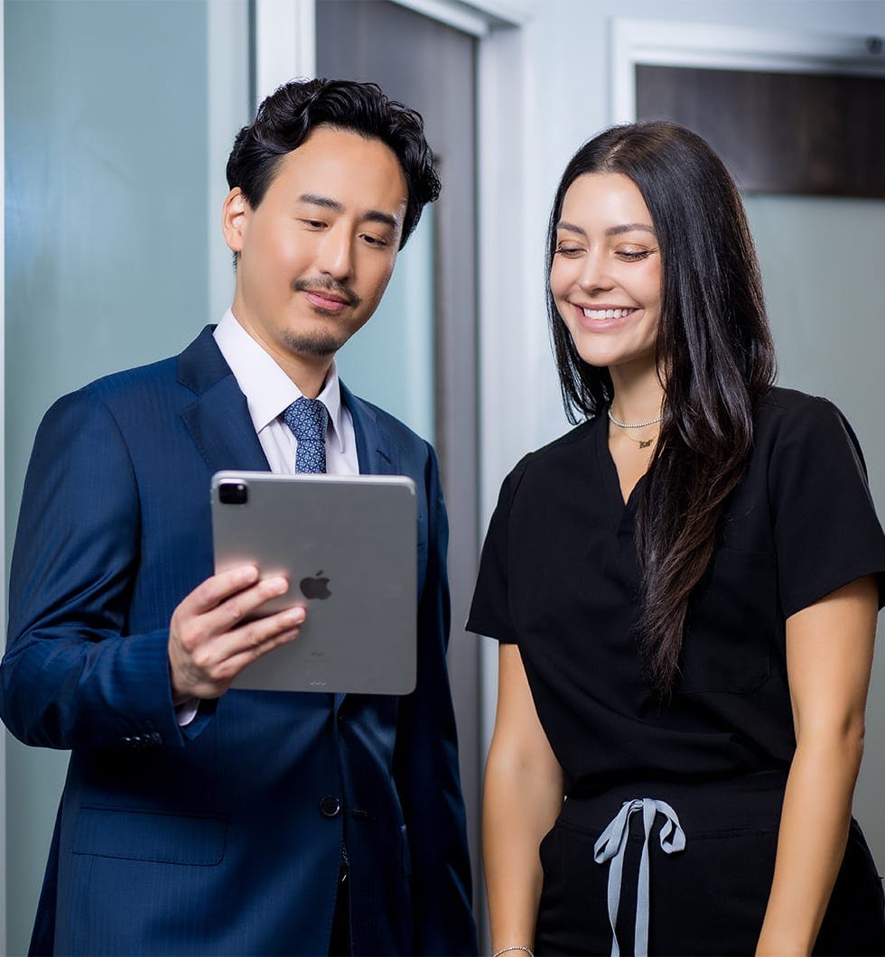 Dr. Michael K. Lee showing staff tablet