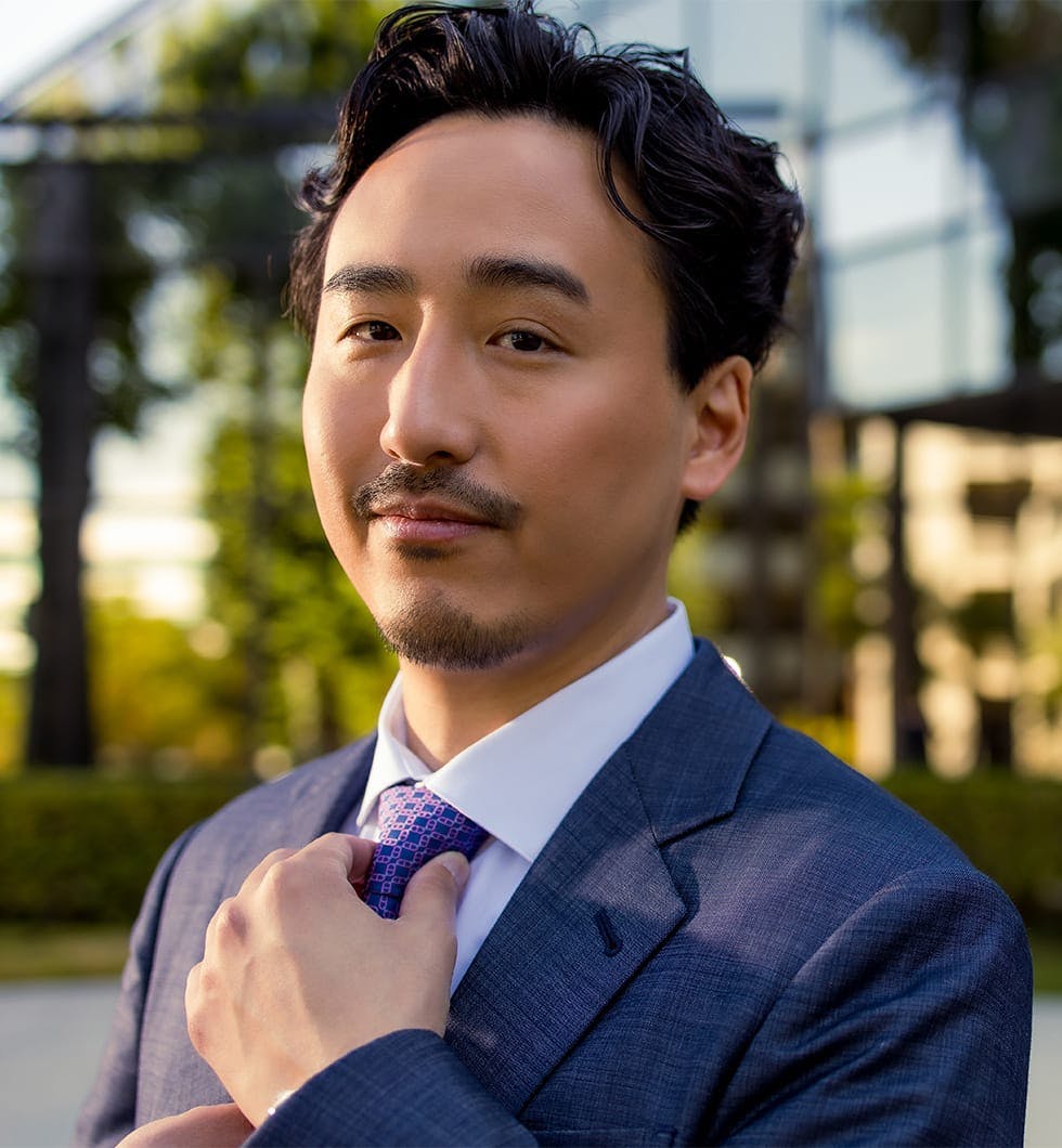 Dr. Michael K. Lee tightening tie and posing for picture