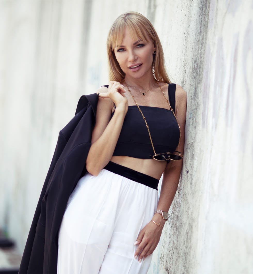 woman leaning against a wall with a black jacket