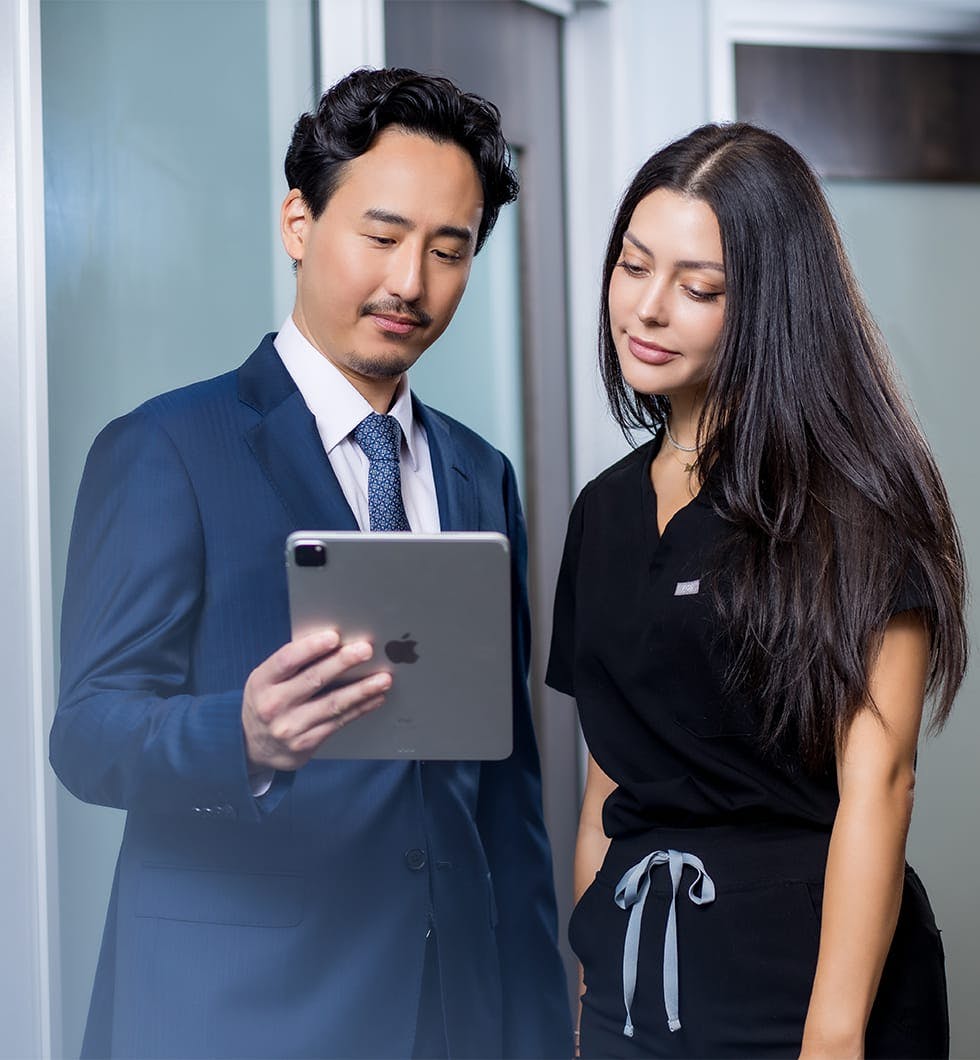 Dr. Michael K. Lee with staff looking at a tablet computer together