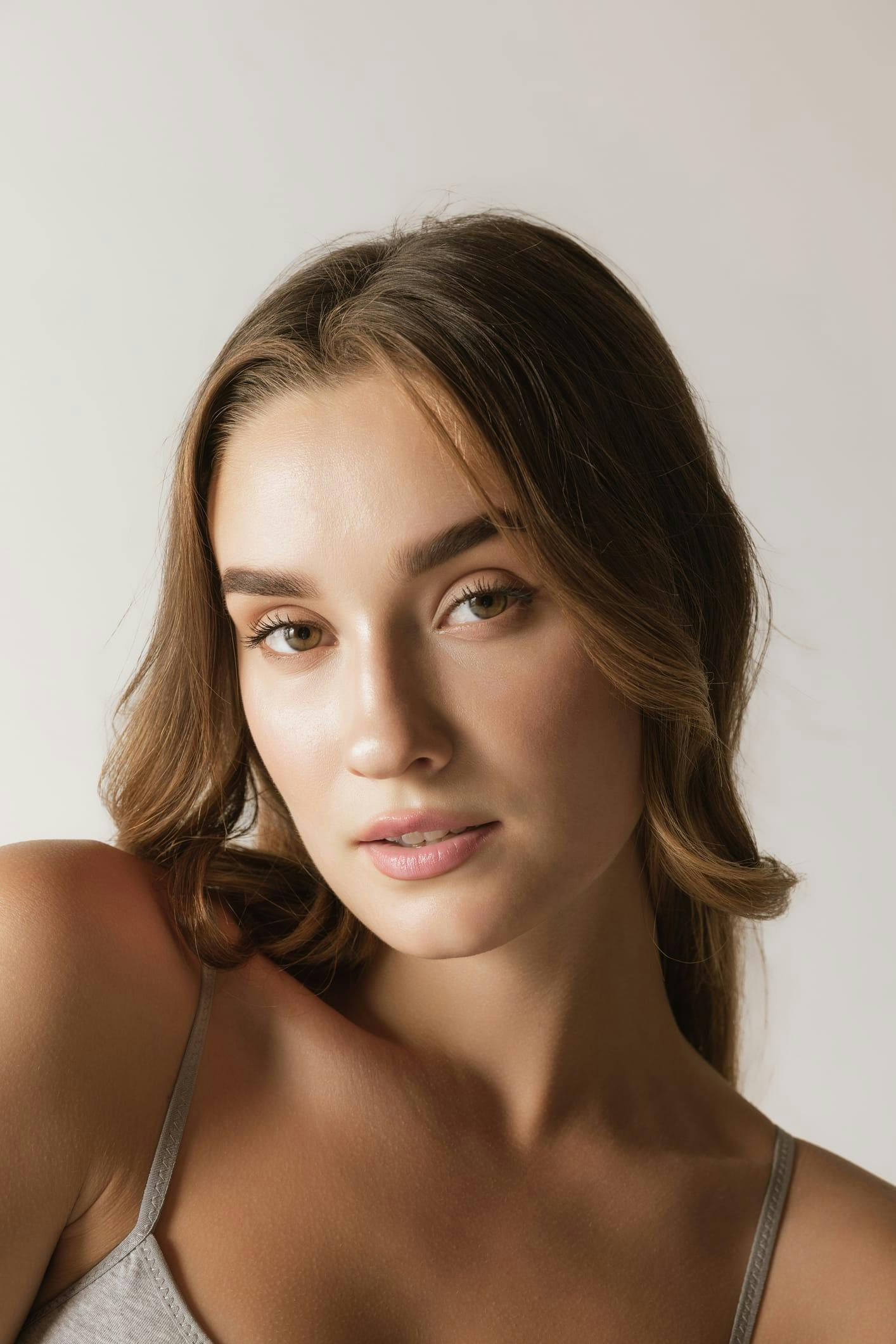 woman with long hair and a gray tank top