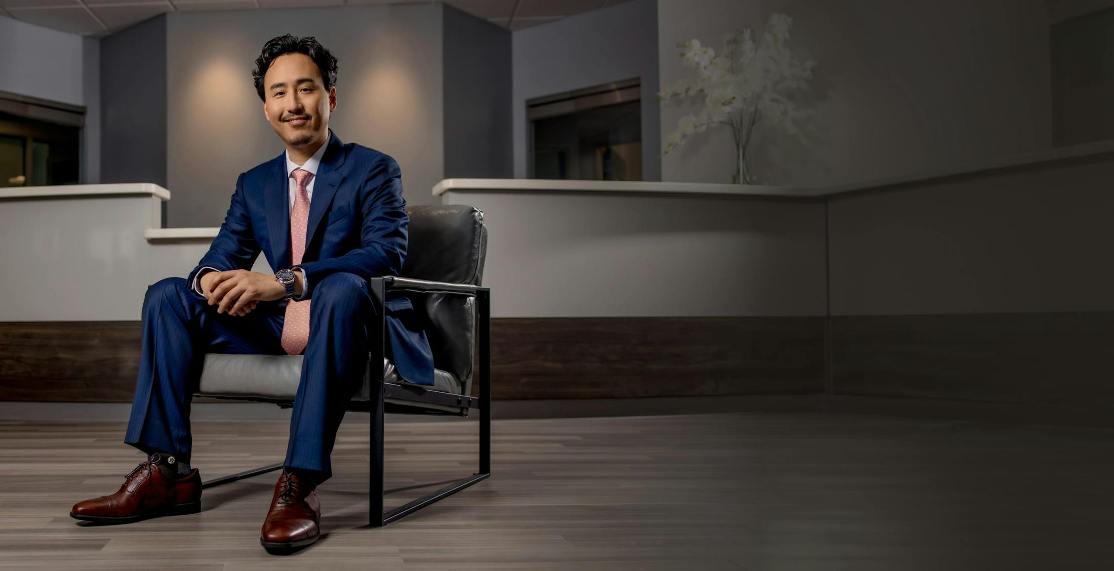 man in a blue suit sitting in a chair