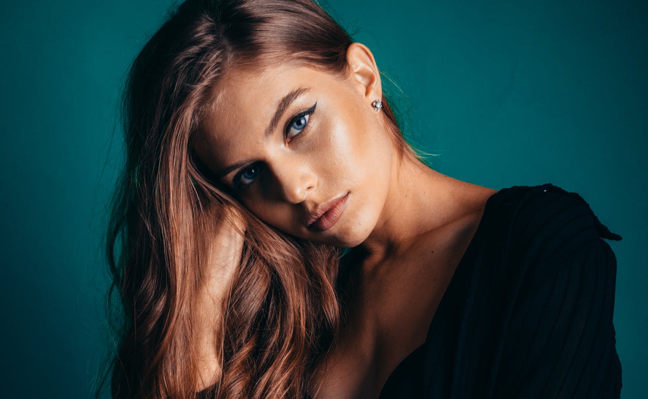 Brunette model holding face in hand