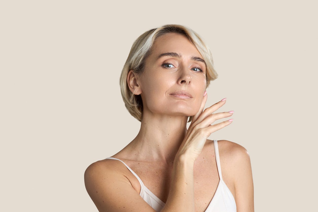 mature woman in white tank top with short blonde hair