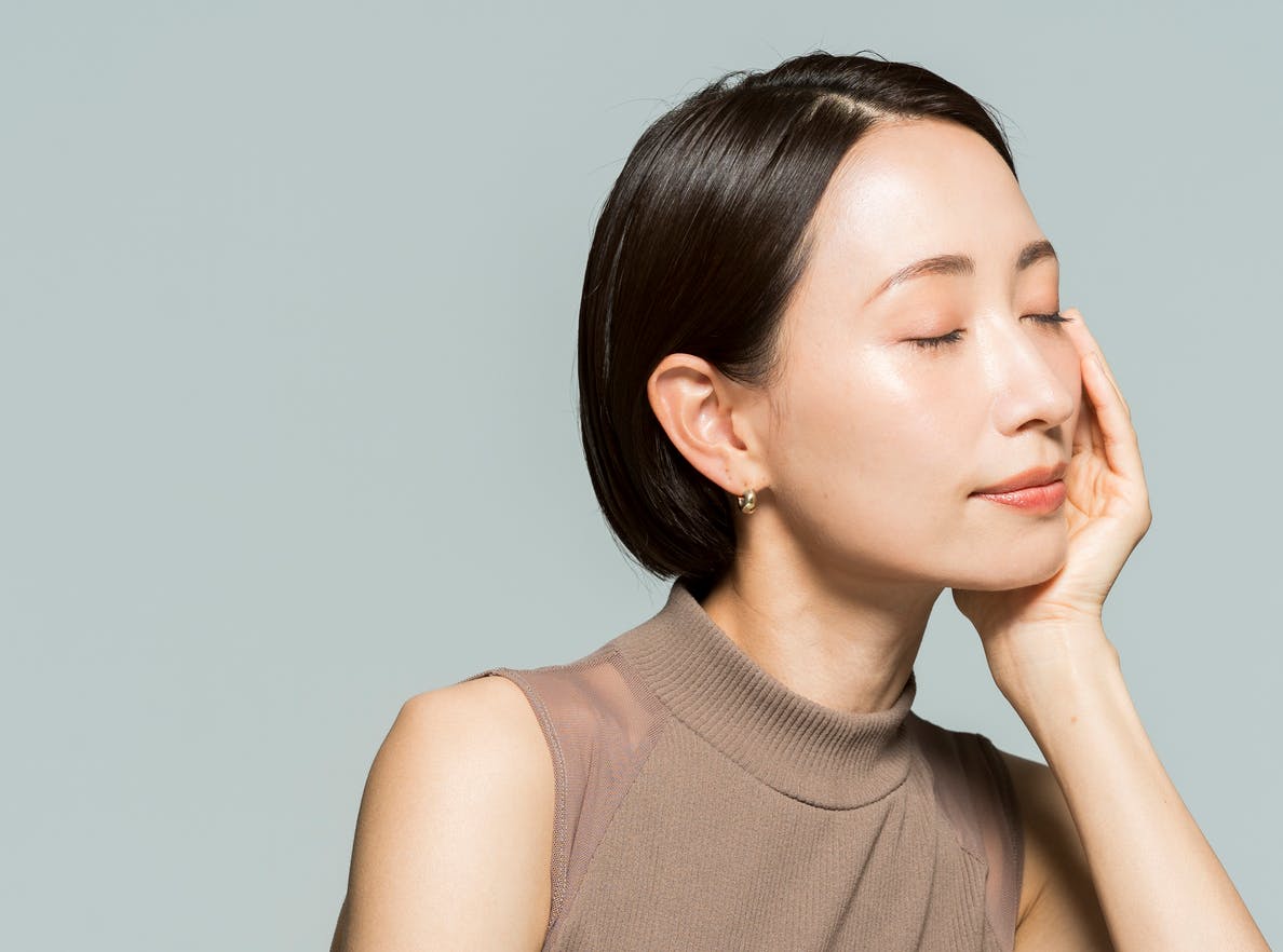 woman with short dark hair closing her eyes