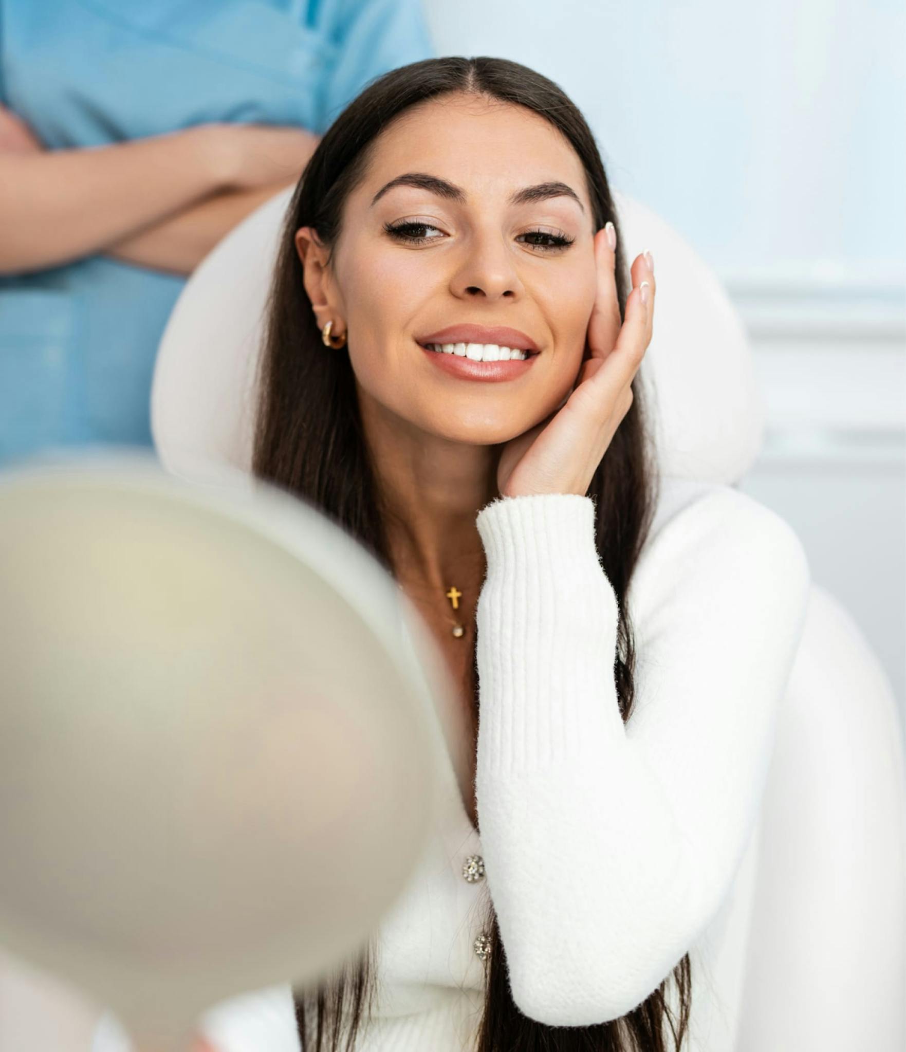 woman smiling and looking into mirror