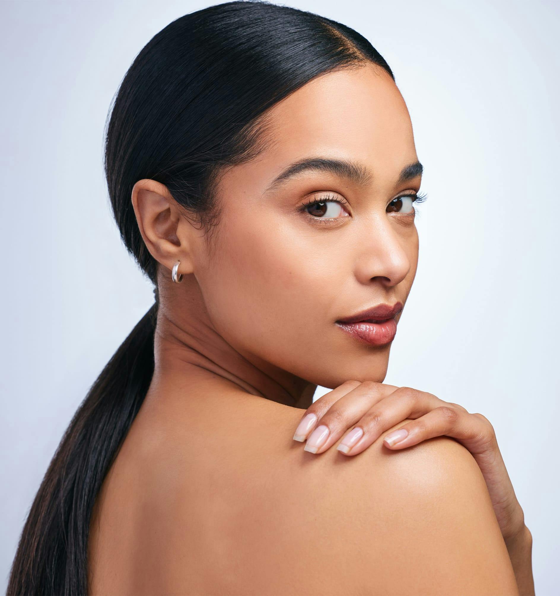 woman with long black hair looking over her shoulder
