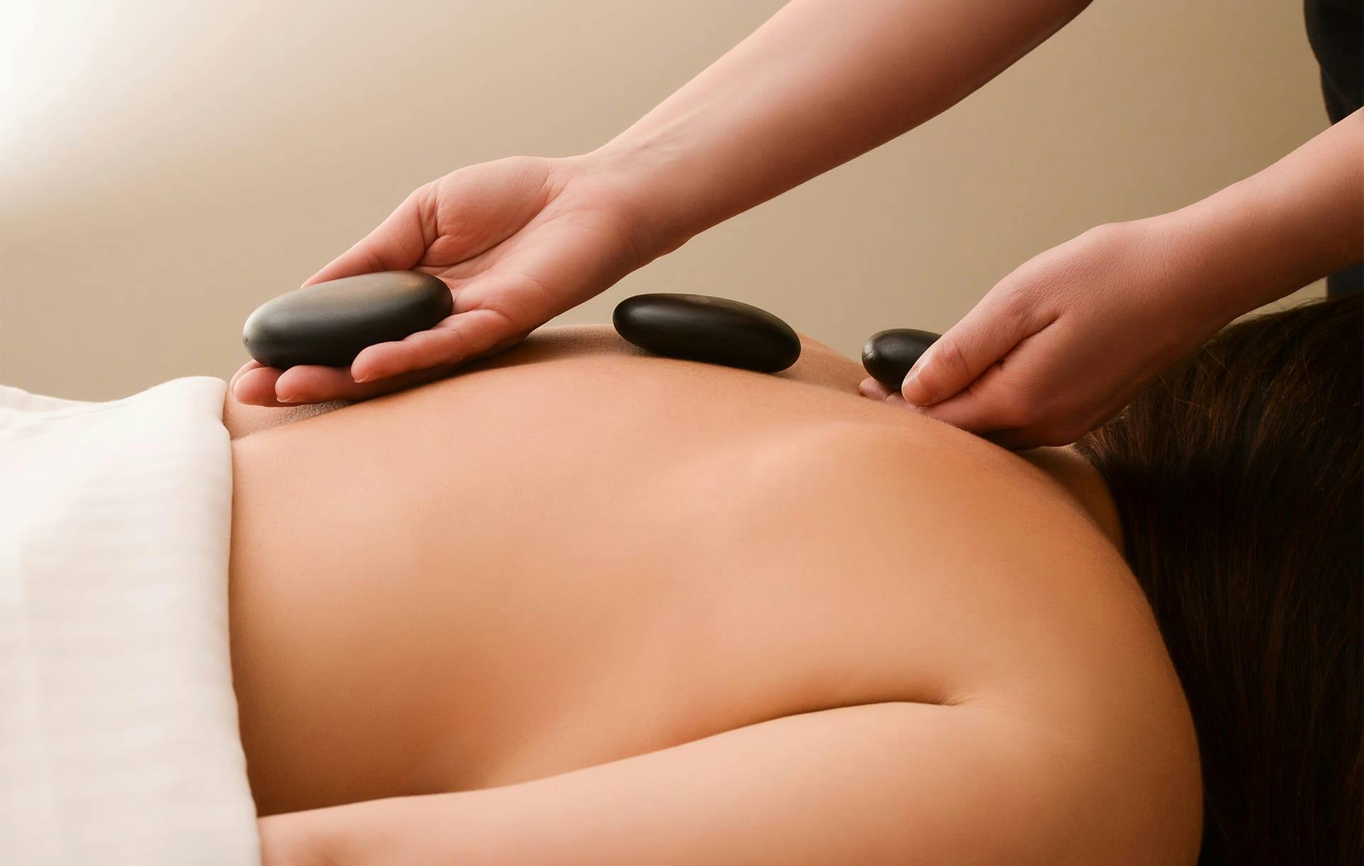 woman with hot rocks on her back