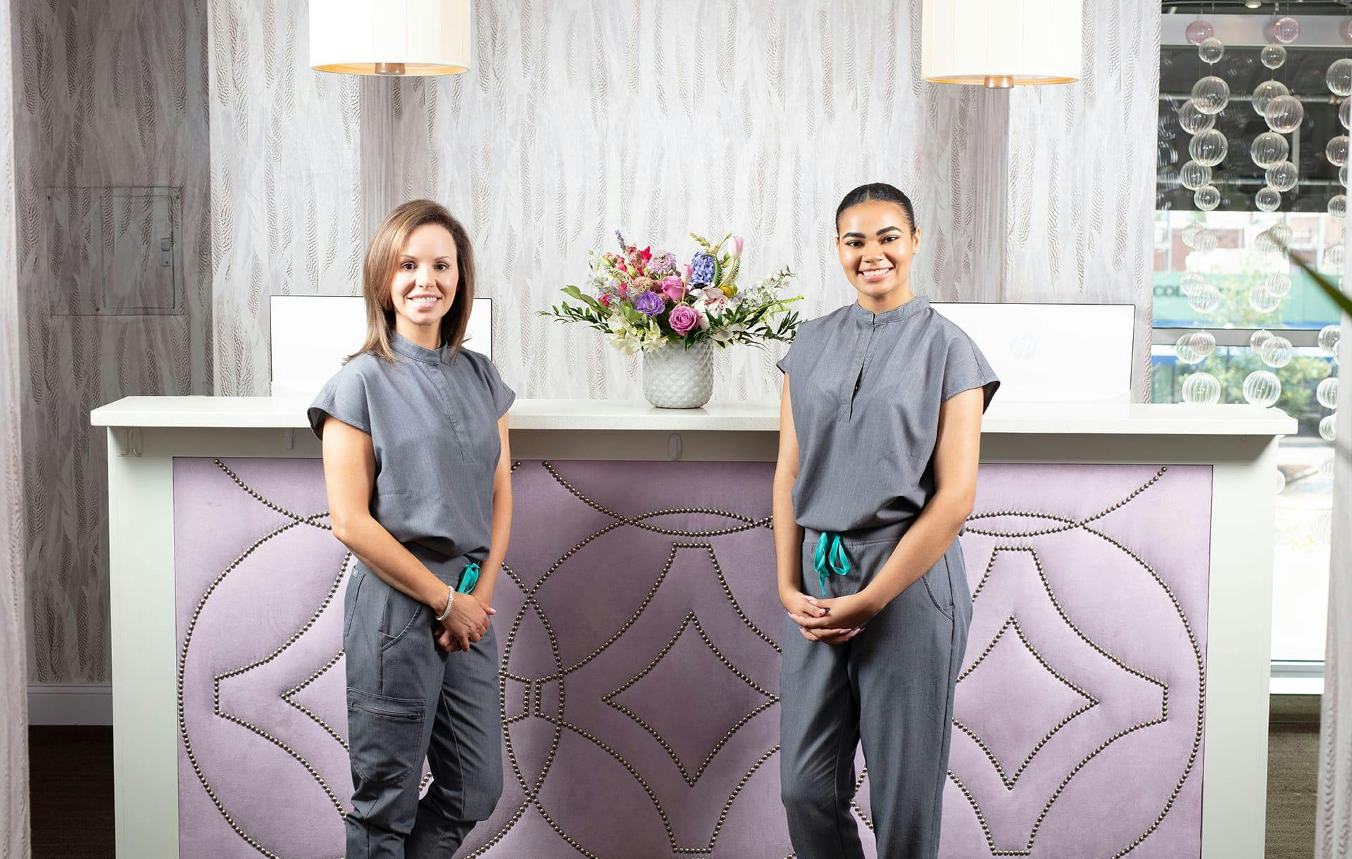 two nurses standing infront of a desk