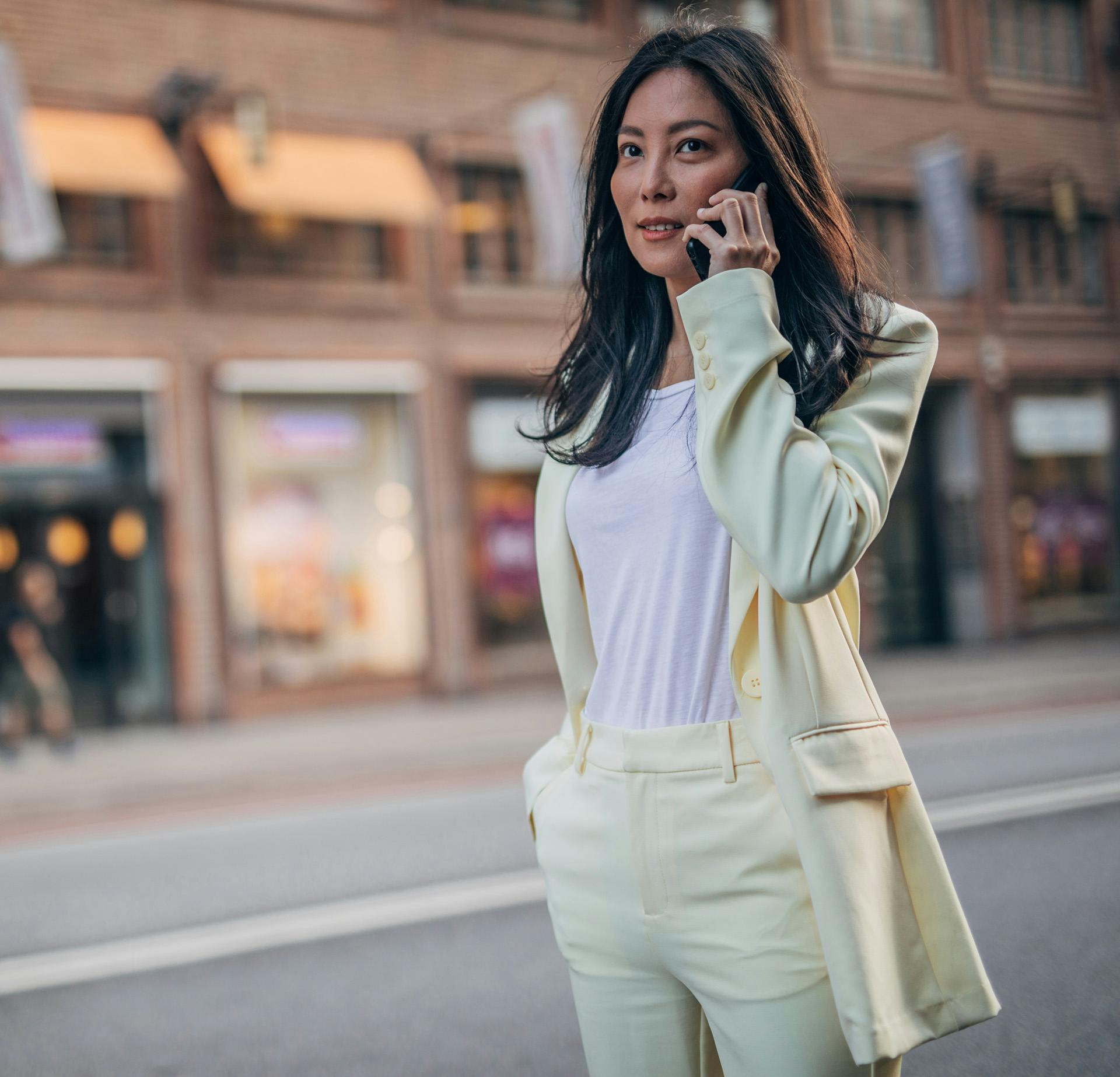 professionally-dressed woman talking on cell phone